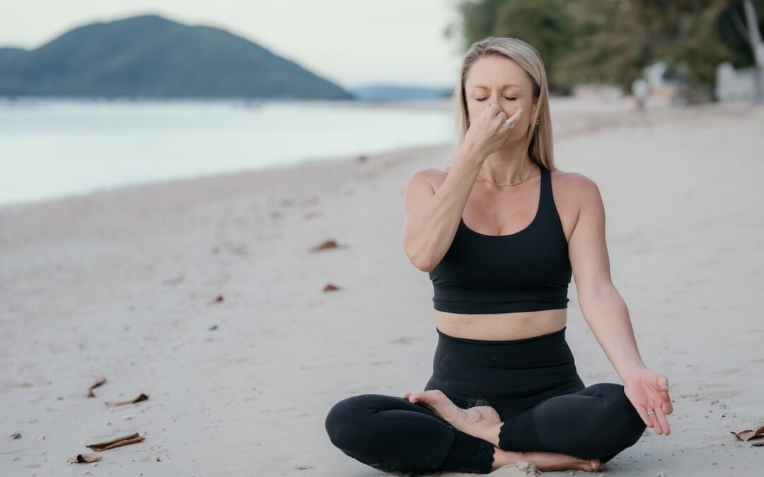 Person practicing pranayama breathwork outdoors, illustrating the connection between breath control and mindfulness, highlighting the importance of breathing techniques in stress management.